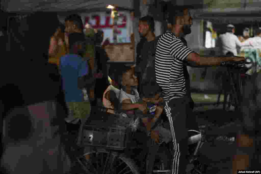 Fëmijë palestinezë duke u vozitur me biçikletë në një zonë pranë plazhit.