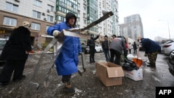 Muncitori curăță resturile din fața unui bloc avariat în urma unui atac cu drone în Krasnogorsk, în regiunea Moscovei, pe 24 octombrie 2025. Atacurile ucrainene de acest fel s-au înmulțit în ultima vreme.