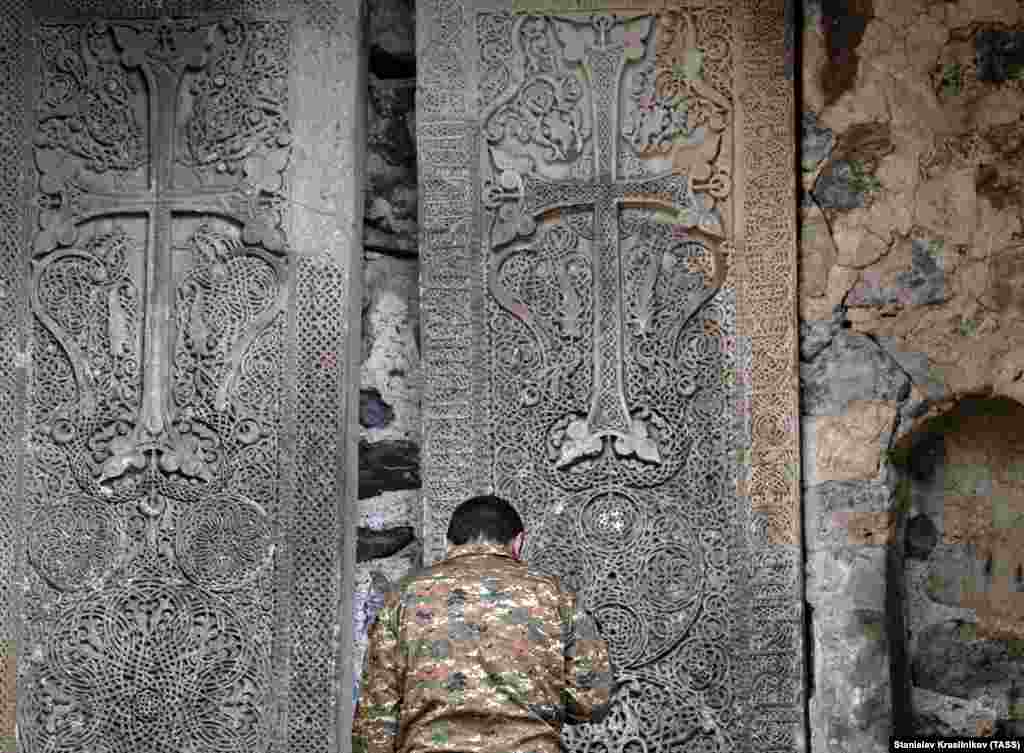 A man prays in front of Dadivank's large cross stones.&nbsp;