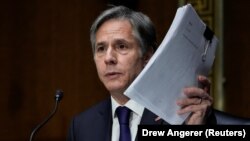 U.S. Secretary of State Antony Blinken holds up documents as he testifies during a Senate Foreign Relations Committee hearing on September 14.