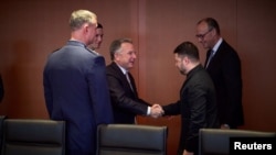 აშშ-ის პრეზიდენტის სპეციალური წარგზავნილი სტივენ უიტკოფი და უკრაინის პრეზიდენტი ვოლოდმირ ზელენსკი ერთმანეთს ესალმებიან. ბერლინი, 2025 წლის 14 დეკემბერი