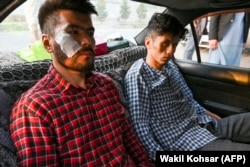 Afghan journalists Neamat Naqdi and Taqi Daryabi arrive at their office after being beaten and detained by the Taliban in Kabul in September 2021.