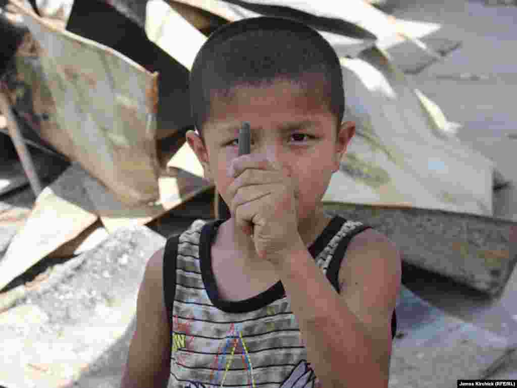 Оштогу "Черёмушки" кичи районунун көчөлөрүнүн биринде атылган окту кармап турган бала. 21-июль, 2010-жыл.&nbsp;