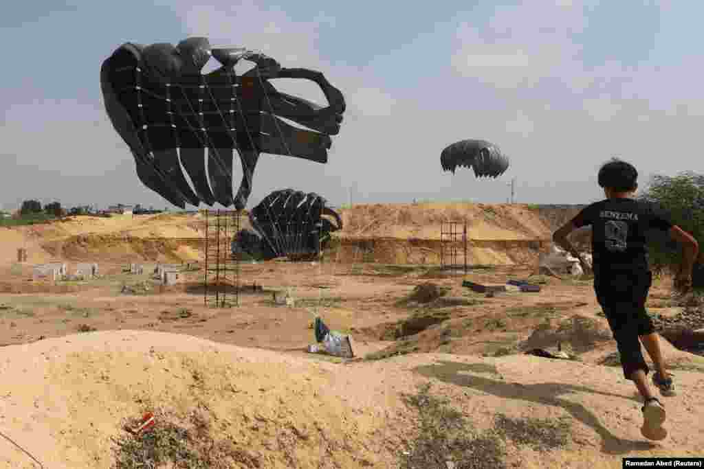 Një djalë palestinez duke vrapuar teksa ndihmat e lëshuara nga ajri binin me parashuta në tokë, në Deir Al-Balah, Gazë, më 12 gusht 2025.