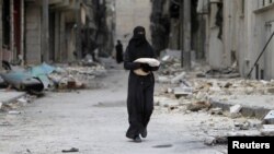 Siriýadaky şäher weýrançylygynyň ortasynda duran aýal