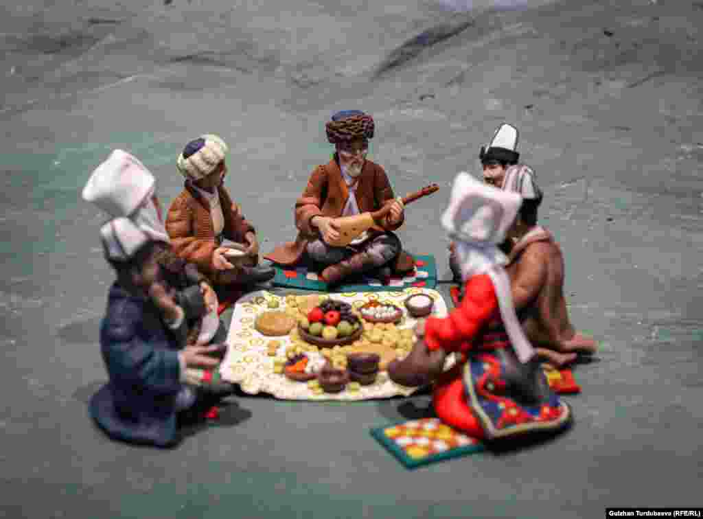 "Улуу көч" деген миниатюралык композициядагы Токтогул Сатылгановдун эл арасында отурган образы.&nbsp;&nbsp;