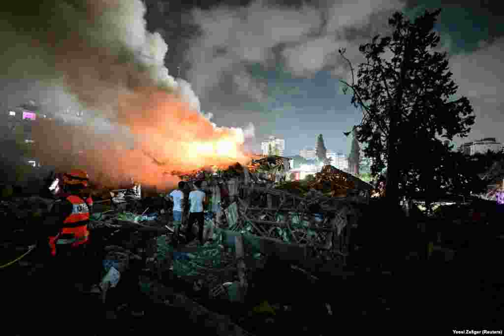 Stanovnici posmatraju požar na lokaciji koju je napao Iran, u centralnom Izraelu, 15. juna.