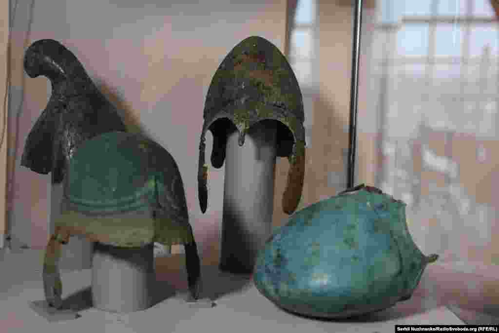 Древнегреческие шлемы. На заднем плане слева – фригийский шлем (конец IV – II вв. до н. э.). На переднем плане слева – северо-причерноморский псевдоаттический шлем (конец IV – середина II в. до н. э.). Справа – два шлема халкидского типа (вторая половина VI – III вв. до н. э.)