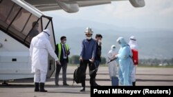 Атайын рейс менен Түштүк Кореядан келген кыргызстандыктарды Алматынын аэропортунда дезинфекциялап жатышат. Казакстан. 14-май, 2020-жыл. 