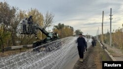  Украински военни инсталират мрежи против дронове над път близо до Добропиля, североизточно от Покровск. 