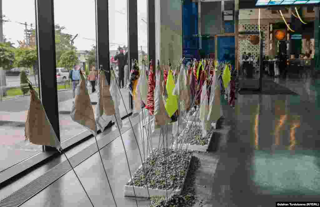 Изилдөөчү Болот Исабековдун "жыртыш" деген эспонаты.&nbsp; "Кыргызда каза болгон аялдын кыздары ал аял чогулткан жоолук, материалдарды майда бөлүкчөлөргө болуп, келгендерге таратып берет. Бул кыркындалар ар бир адамга маркум жөнүндө эскерүүнү сактап калгууга мүмкүнчүлүк берет".&nbsp; &nbsp; &nbsp;