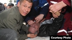 Ереуілшілер есінен танып құлаған Өтеміс Омаровқа көмек көрсетуде. Жаңаөзен, 18 наурыз 2010 жыл. Сурет ақтаулық «Лада» газетінің www.lada.kz сайтынан алынды. Сүрет ауторы -  Ольга Ярославская.