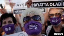 Коргоочу беткапка "Стамбул келишимин турмушка ашыр!" деген талапты жазып, нааразылык жыйынга чыккандар. Стамбул, Түркия. 2020-жылдын 5-августу.