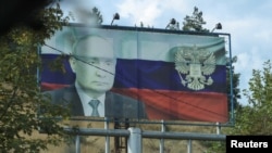 Nagorno-Karabakh - A board displaying a Russian state flag and an image of President Vladimir Putin is seen in Stepanakert following a military operation conducted by Azeri forces, October 2, 2023.
