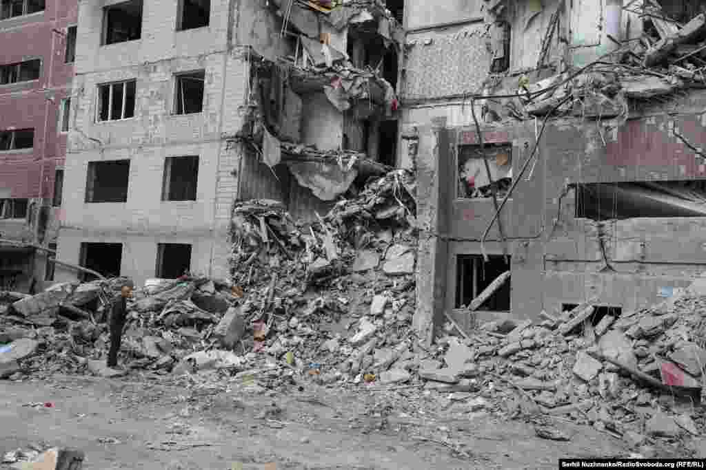 Un bărbat încearcă să sune o femeie prinsă sub dărâmături. Mai târziu, salvatorii îi vor găsi trupul neînsuflețit.