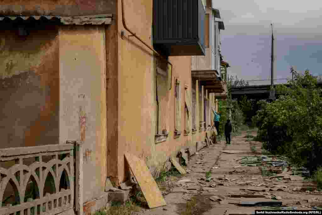 Locuitorii rămași în oraș își astupă geamurile cu placaje de lemn.