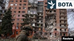 Një ushtar ukrainas kalon pranë një ndërtese banimi të dëmtuar nga sulmet ushtarake ruse në qytetin Pokrovsk, në vijën e frontit, më 6 mars.