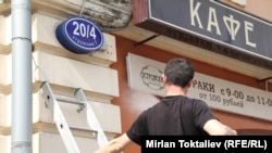 Мужчина чистит фасад кафе в Москве, 2012 год.