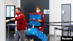 Personal medical transportă doze de vaccin la un centru din Salzburg, în 31 ianuarie, cu o zi înainte de intrarea în vigoare a obligativității vaccinării anti-Covid.