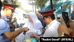 Tajik police take Gulhehra Shodmonova (center) into custody shortly after she had doused herself in gasoline on September 7.