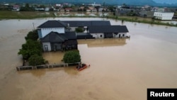 İndoneziyada xilasedicilər daşqından zərər çəkmiş sakinlərin təxliyəsi üçün şişmə qayıqdan istifadə edirlər.