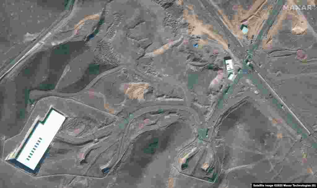 ფორდოს მიწისქვეშა ობიექტის შესასვლელთან სატვირთო მანქანები და ბულდოზერები ჩანს.