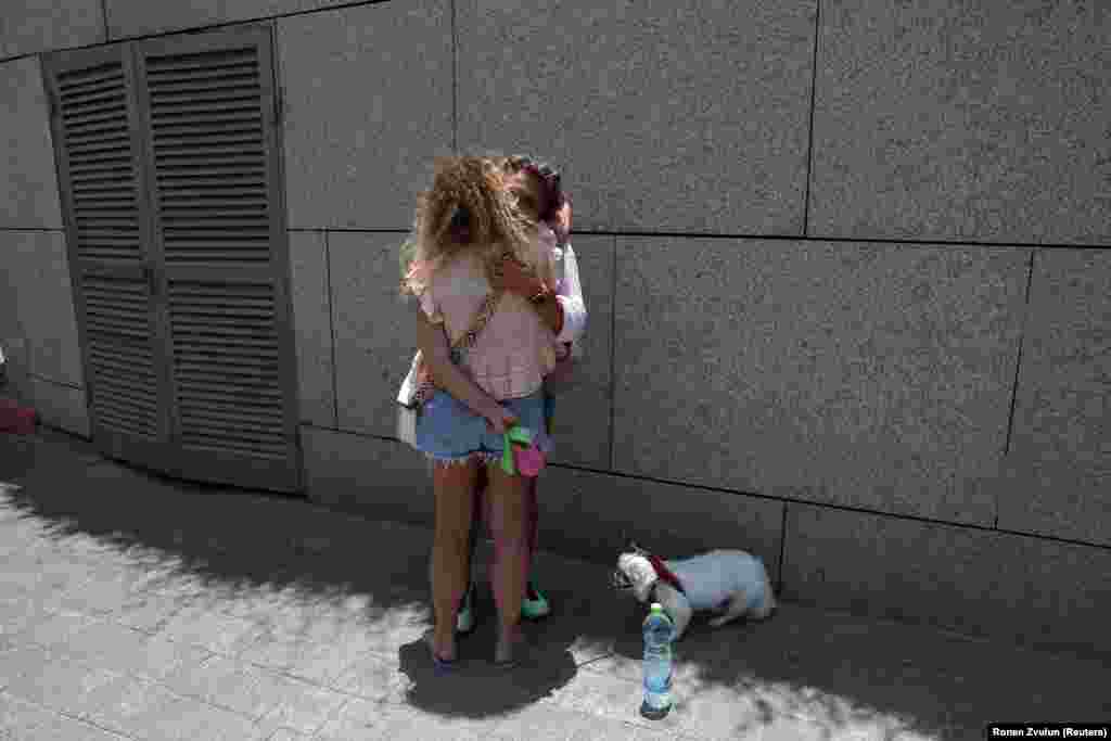 Dvoje ljudi se grle dok se strani državljani spremaju da napuste Izrael autobusom preko Egipta, nakon iranskog raketnog napada, u Tel Avivu, 17. juna.