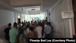 Angajați ai Ministerului de Finanțe protestează pe holul instituției publice.