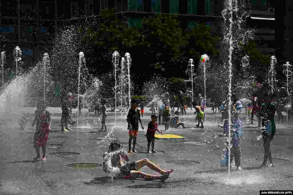 Djeca i odrasli se rashlađuju na trgu Andre-Citroen u francuskoj prijestolnici 29. juna.