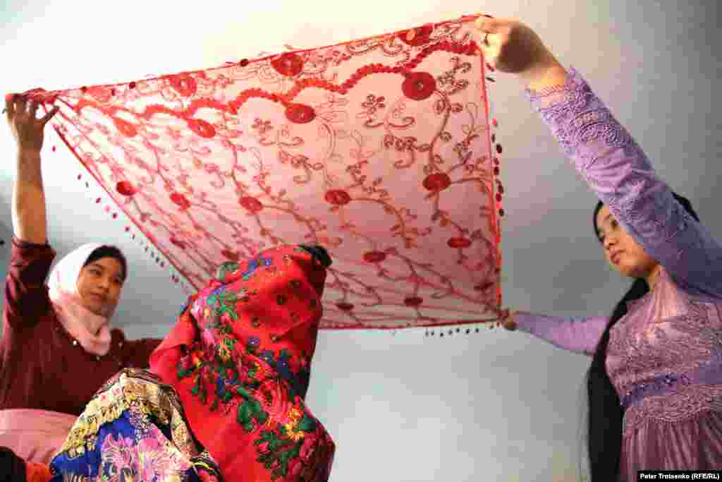 Перед тем как невеста покинет родной дом, ее лицо закрывают платком, поверх которого накидывается еще один. Первый платок (из дома жениха) &ndash; символ того, что невеста становится членом новой семьи. Второй платок, согласно традиции, должен быть из дома матери.