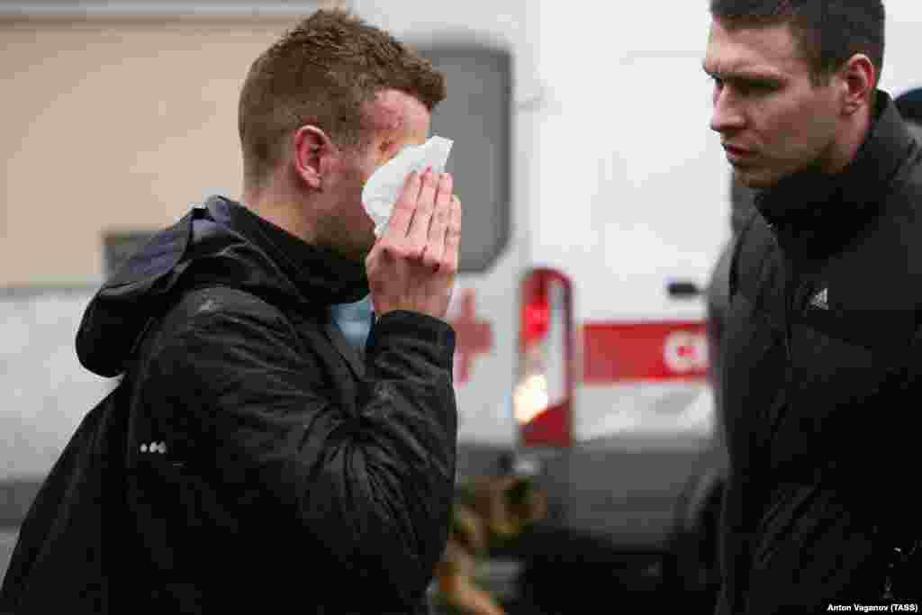 An injured person stands outside the Sennaya Ploshchad subway station.