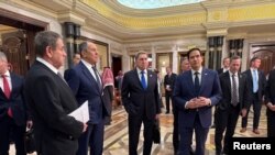 აშშ-ის სახელმწიფო მდივანი მარკო რუბიო, რუსეთის საგარეო საქმეთა მინისტრი სერგეი ლავროვი, რუსეთის პრეზიდენტის ვლადიმირ პუტინის მრჩეველი საგარეო პოლიტიკის საკითხებში იური უშაკოვი და დელეგაციის სხვა წევრები. ელ-რიადი, 2025 წლის 18 თებერვალი.