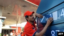 په کراچۍ کې د پمپ یو کارکوونکی د تېلو بیې بدلوي - پخوانی انځور.