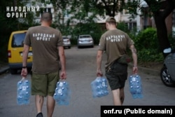 Активисты российской провластной организации «Народный фронт» разносят питьевую воду жителям оккупированных регионов Донбасса во время водного кризиса, август 2025 года