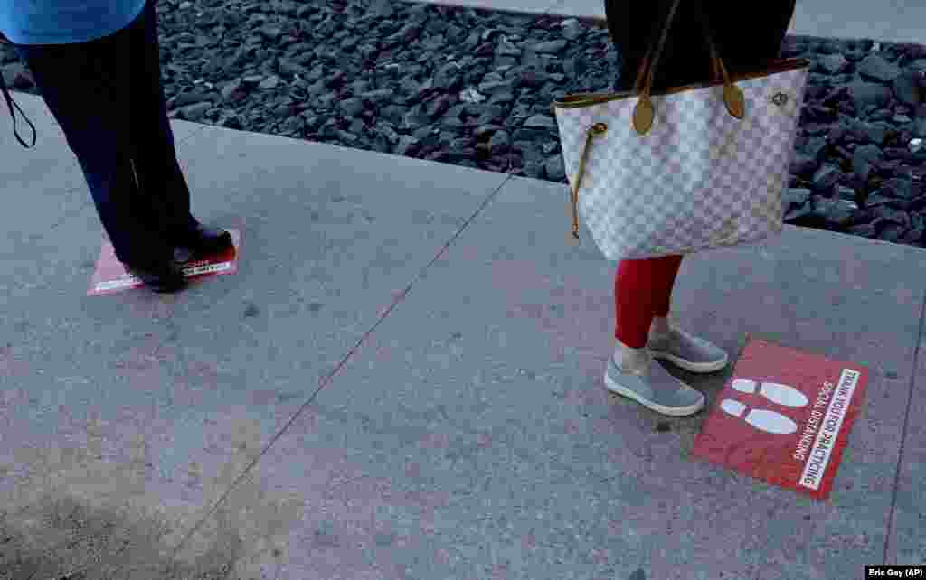 Знаци кои помагаат во социјалното растојание меѓу купувачите кои чекаат на ред во самопослуга во Остин, Тексас.