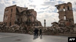 Disa sirian; duke kaluar pranë kalasë historike të Alepos, e cila është shkatërruar. 5 dhjetor 2024.

