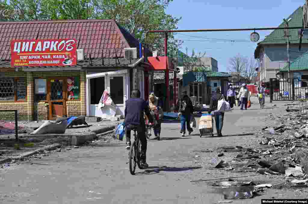 Рынок остается центром жизни – люди собираются там каждый день, несмотря на опасность. Здесь торгуют вещами и едой, и спрашивают друг друга о новостях – ни связи, ни энергоснабжения в городе сейчас нет