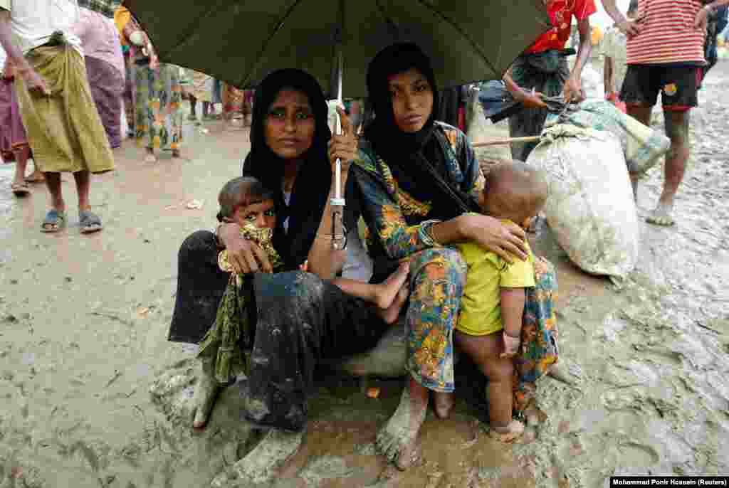 Рохинджа качаклары Бангладыш чиген канунсыз узган өчен чик сакчылары тарафыннан тоткарланганнан соң көчле яңгыр астында утыра.