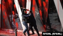 Полицаи избутва протестиращ пред сградата на ЕК в София.