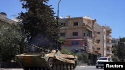 Un vehicul militar circulă pe o stradă, după ce ciocnirile dintre trupele guvernamentale siriene și luptătorii druzi locali au fost reluate în orașul druz Sweida, din sudul țării, miercuri dimineață, rupând un armistițiu anunțat cu doar câteva ore mai devreme.