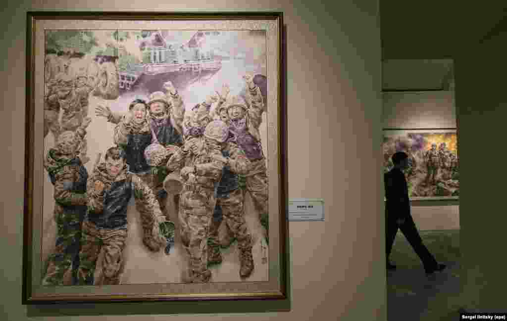 Сүрөт "Чоң ийгиликтен кийинки кубаныч" деп аталат.Орусия Украинага каршы толук масштабдуу согушуна Түндүк Кореянын аскерлерин да тартып жатканын 2024-жылдын октябрында Түштүк Кореянын чалгын кызматы айтып чыкканда Москва муну караманча калп деп, четке каккан эле. Кремлдин басма сөз катчысы Дмитрий Песков маалыматты фейк деп атаган.