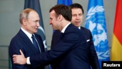 Рускиот претседател Владимир Путин се ракува со францускиот претседател Емануел Макрон за време на самитот за Либија во Берлин, Германија, 19 јануари 2020 година.