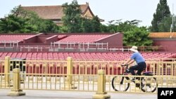 Un biciclist, trecând prin fața tribunelor din piața Tiananmen din Beijing pregătite pentru parada militară de pe 3 septembrie 2025 pentru a marca 80 de ani de la victoria Chinei asupra Japoniei și sfârșitul Celui de Al Doilea Război Mondial