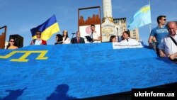 Під час акції до Дня кримськотатарського прапора у Києві, 26 червня 2019 року. Люди пронесли центром столиці України 40-метровий кримськотатарський прапор, який об'їздив 28 країн
