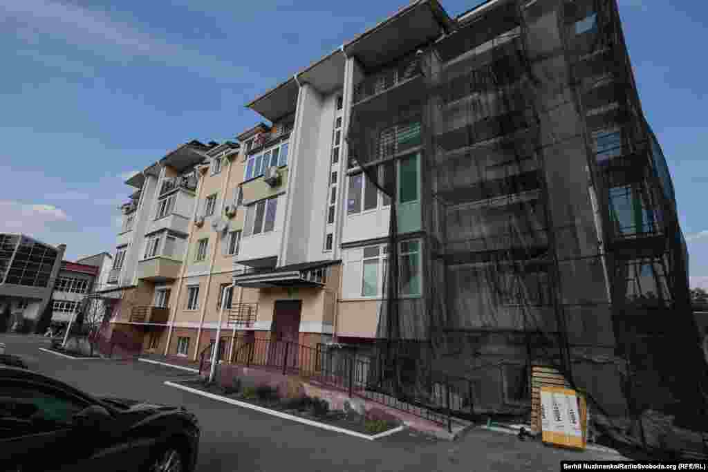 У адным з раёнаў Ірпяня пашкоджаны жылы дом. Адны дамы рамантуюць практычна з нуля, а ў іншых, як на фота, за тры гады аднавілі толькі пашкоджаны фасад.Зьлева фота 11 сакавіка 2022 году, справа — з сакавіка 2025 году