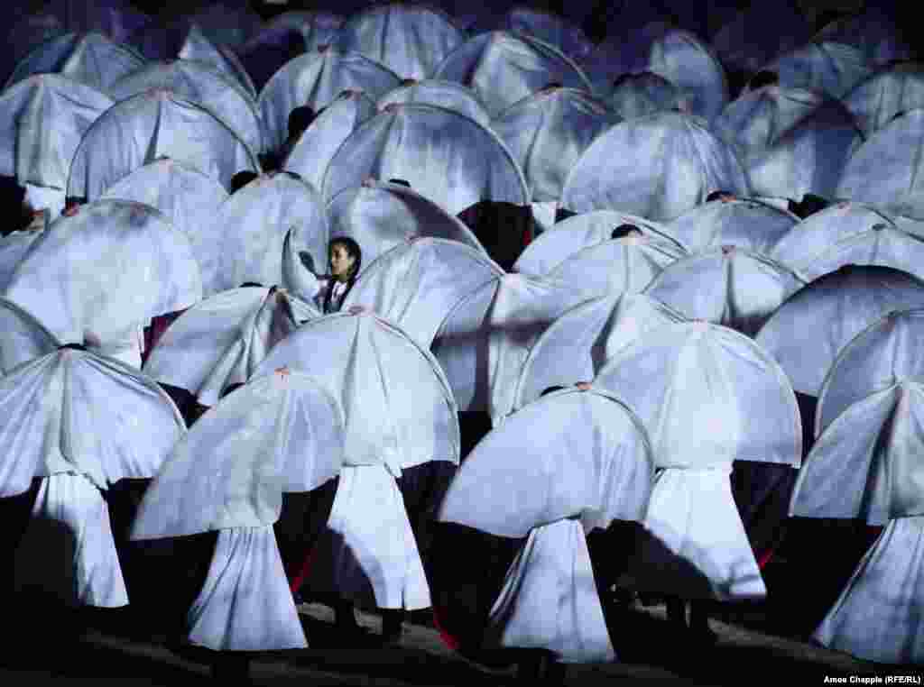 Ачылыш аземиндеги бийчилер. Оюндар Тян-Шан тоолору курчап турган Ысык-Көлдүн жээгинде өтүүдө.