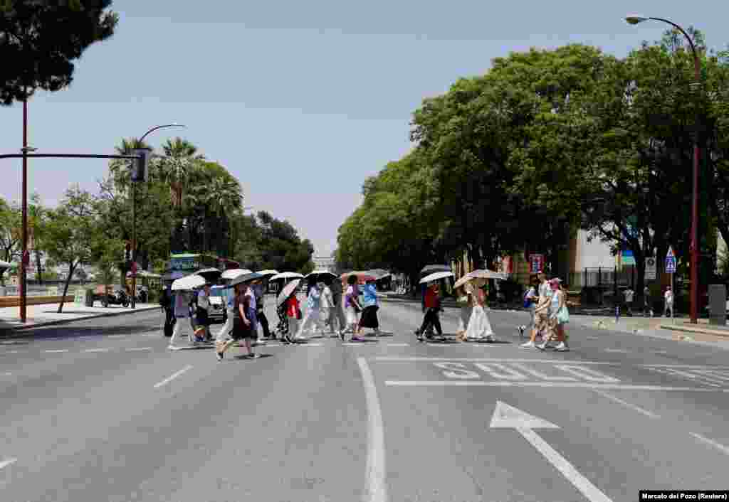 Turisti pod suncobranima u Sevilji, 29. juna.