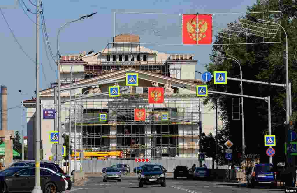 Вывески с изображением российского герба выставлены на улице, Мариуполь, контролируемый Россией, 6 августа 2025 года. REUTERS/Александр Ермоченко