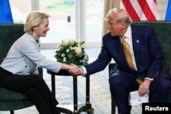 Președintele SUA, Donald Trump, dă mâna cu președinta Comisiei Europene, Ursula von der Leyen, după anunțarea unui acord comercial între SUA și UE, la Turnberry, Scoția, Marea Britanie, 27 iulie 2025.