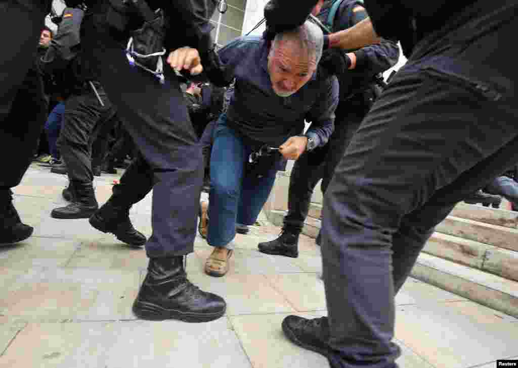 Pripadnici Civilne garde odvlače muškarca u mestu Sant Julia de Ramis.